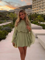 Short women's dress in light green with ruffles and long sleeves for evening wear