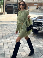 Short women's dress in light green with ruffles and long sleeves for evening wear