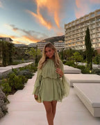 Short women's dress in light green with ruffles and long sleeves for evening wear