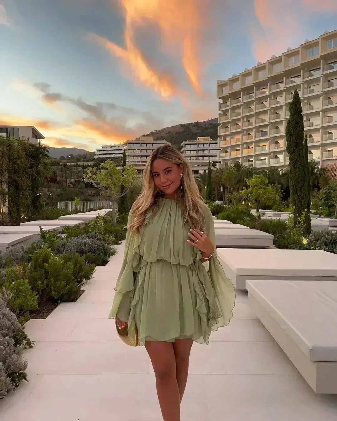 Short women's dress in light green with ruffles and long sleeves for evening wear