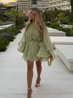 Short women's dress in light green with ruffles and long sleeves for evening wear