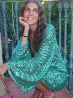 Short women's shimmering dress with plunging neckline and flared sleeves