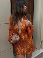 Short women's shimmering dress with plunging neckline and flared sleeves