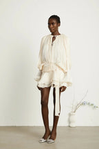Short fluid dress with long sleeves and tied belt